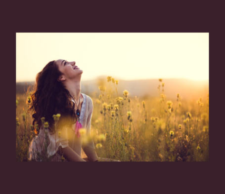 Femme louant Dieu dans un champ de fleurs au coucher du soleil.