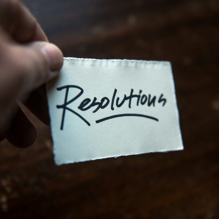 Un morceau de papier avec le mot "Résolutions" écrit en noir.